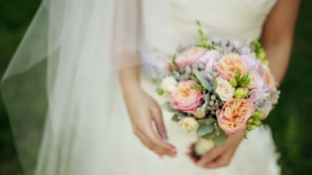 Bride holds a wedding bouquet in her hands — Stock Video