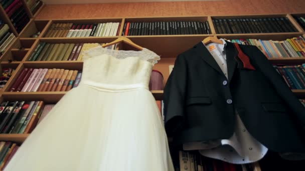 Bruiloft jurk en pak opknoping op een hangers — Stockvideo