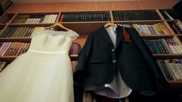 Vestido de novia y traje colgando de una percha — Vídeo de stock