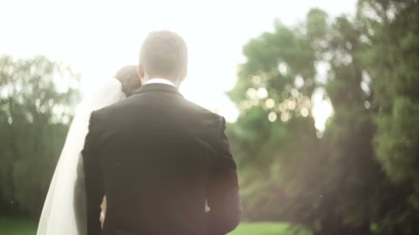 Noiva noivo de mãos dadas ao pôr do sol no parque — Vídeo de Stock