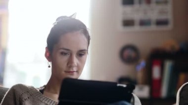 Güzel kadın kanepe oturma ve tablet kullanma.