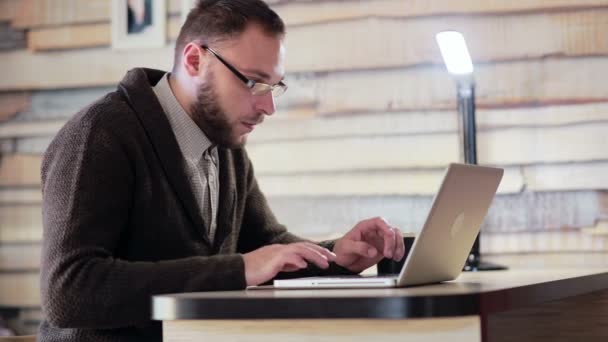 Hombre trabajando en el ordenador portátil en el lugar de trabajo — Vídeos de Stock