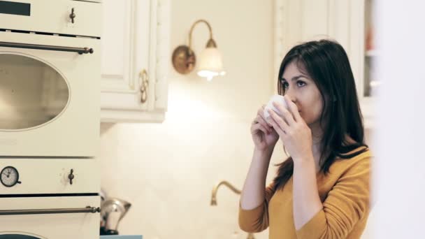 Frau genießt Morgenkaffee in heller Küche — Stockvideo