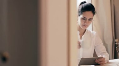 Tablet kullanma ve içme kahve tablo tarafından kadın