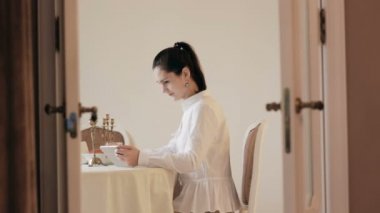 Tablet kullanma ve içme kahve tablo tarafından kadın