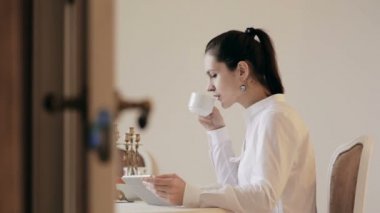 Tablet kullanma ve içme kahve tablo tarafından kadın