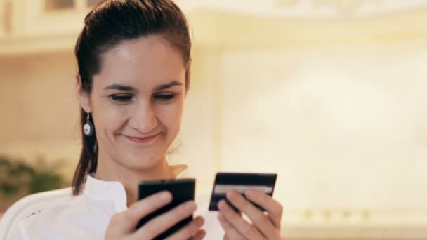 Mujer de compras en línea con el teléfono móvil en casa — Vídeos de Stock