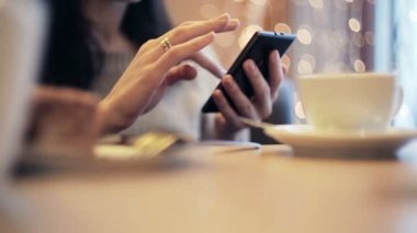 Kadın el manifatura, kafede Smartphone kullanarak.