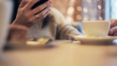 Kadın el manifatura, kafede Smartphone kullanarak.