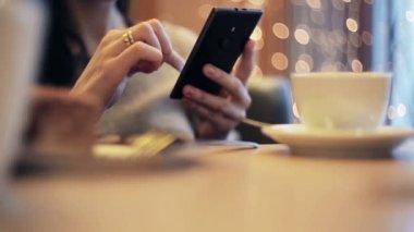 Kadın el manifatura, kafede Smartphone kullanarak.