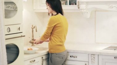 Güzel kız mutfakta elma yıkar