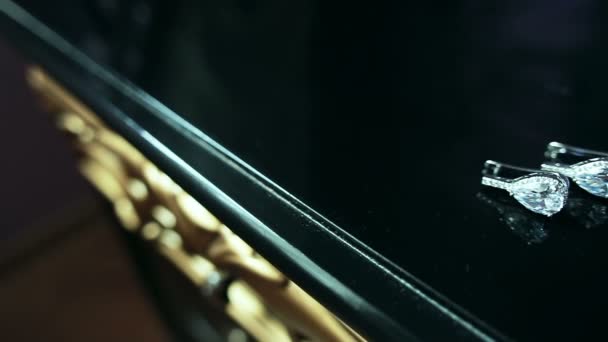 Красиві сережки на темному класичному дерев'яному столі . — стокове відео