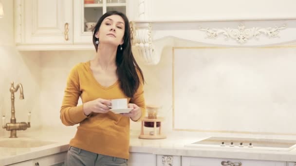 Όμορφη κοπέλα απολαμβάνοντας καφέ στην κουζίνα — Αρχείο Βίντεο