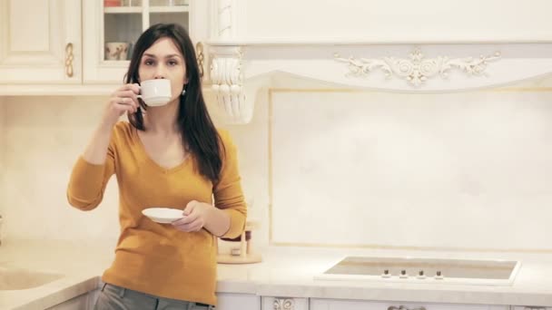 Fiatal gyönyörű lány élvezi a konyhában kávé — Stock videók