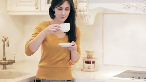 Jovem menina bonita desfrutando de café na cozinha — Vídeo de Stock