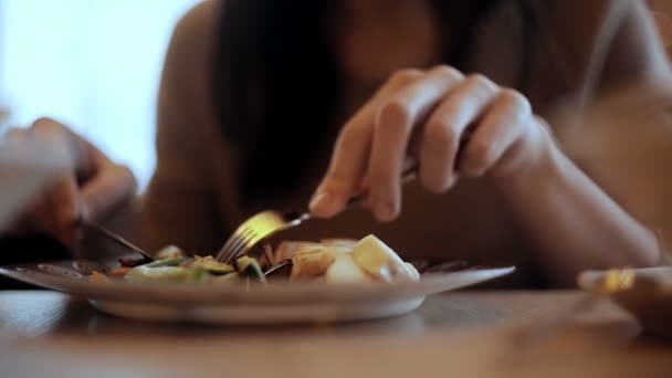 Woman eats vegetable and meat in cafe — Stock Video