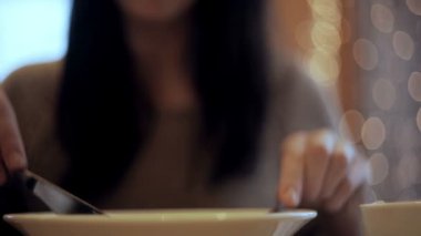 Kadın sebze salatası kafede yiyor.