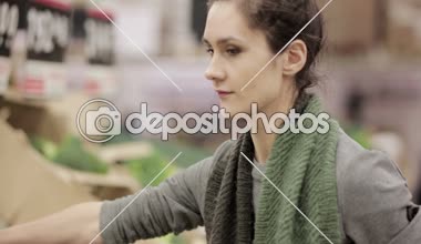 Genç kadın lahana üstünde stok rafa koymak seçer.