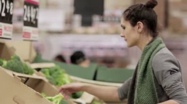 Genç kadın lahana üstünde stok rafa koymak seçer.