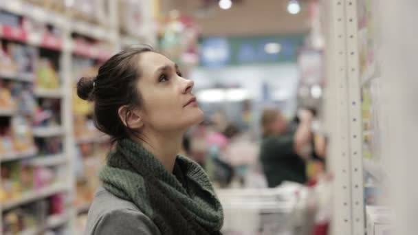 Girl selects the item on the shelves in the store — Stock Video