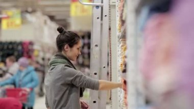 Genç kadın havlu süpermarkette seçer.