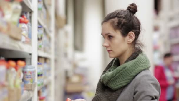 Jonge vrouw kiest babyvoeding in de supermarkt — Stockvideo