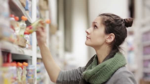 Young woman chooses baby food in the supermarket — Stock Video