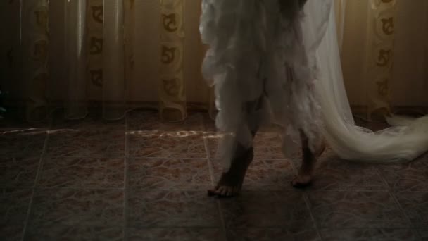 Дівчина нахиляється босоніж в красивому пігирі — стокове відео