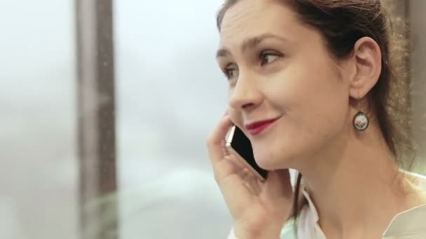 Женщина разговаривает по телефону в движущемся лифте — стоковое видео