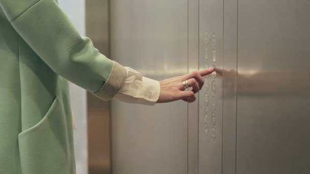 Mão das mulheres pressiona botão. portas do elevador fechadas — Vídeo de Stock