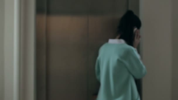Žena hovoří do telefonu a vstoupí do výtahu — Stock video