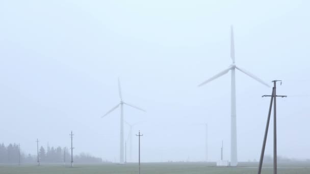 Molinos de viento cerca de la mañana brumosa carretera . — Vídeo de stock