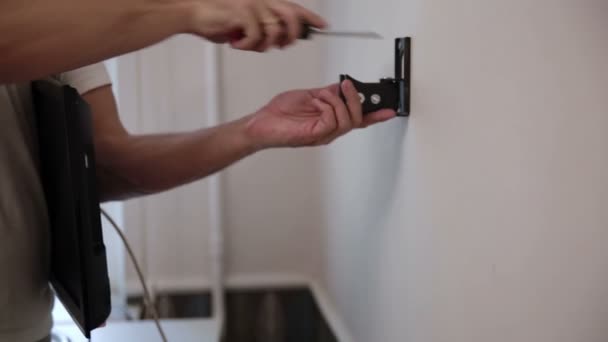 El hombre instala el soporte en la pared. instalar TV — Vídeos de Stock