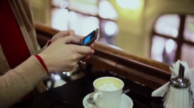 Kadın el manifatura, kafede Smartphone kullanarak.