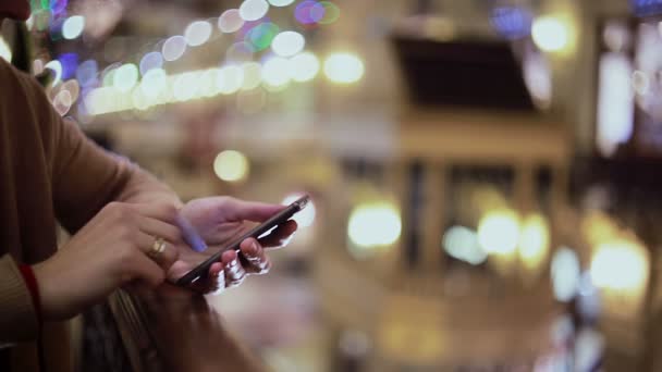 Kvinnens hender sender SMS med smarttelefon på kjøpesenteret. . – stockvideo