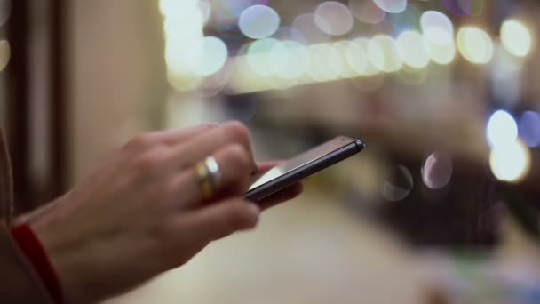 Las manos de la mujer mensajes de texto, utilizando el teléfono inteligente en el centro comercial . — Vídeos de Stock