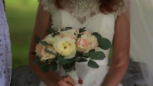 Невеста на качелях, держа букет в руках — стоковое видео