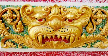 Dev heykelin T tapınağında seramik duvar üzerine altın kızgın yüzü