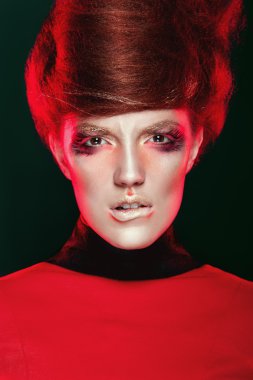 Kırmızı siyah arka plan üzerine yaratıcı makyaj ile sıcak kız