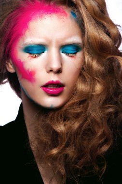Kıvırcık saçlı ve beyaz arka plan üzerinde yaratıcı makyaj güzel kadın