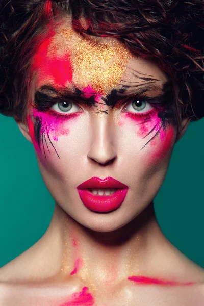 Beautifulgirl met creatieve kleurrijke make-up op een groen — Stockfoto