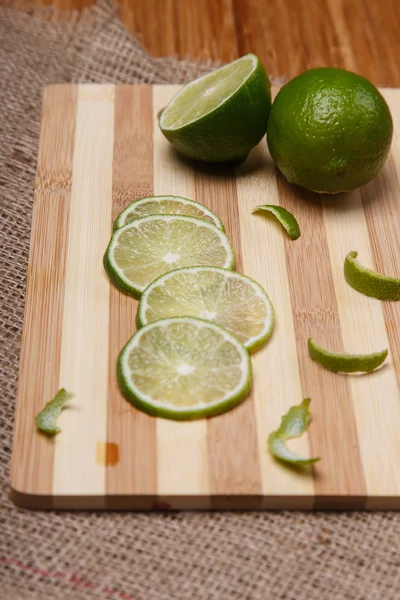 Ahşap bambu mutfak pano portre dilimleri ile taze yeşil limon