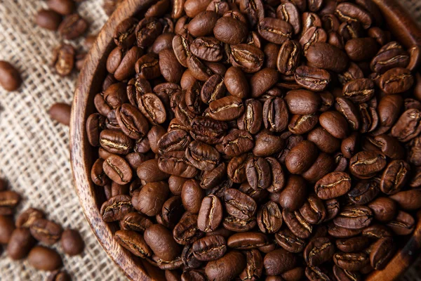 Kahve çekirdekleri çanta üzerinde bir ahşap tabak