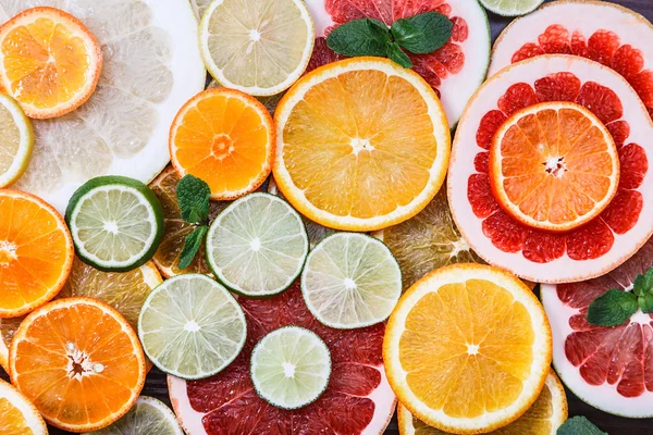 Skivad citrus: apelsiner, mandariner, citroner, limefrukter, sötnos, grapefrukt, häxans kvast närbild makro — Stockfoto