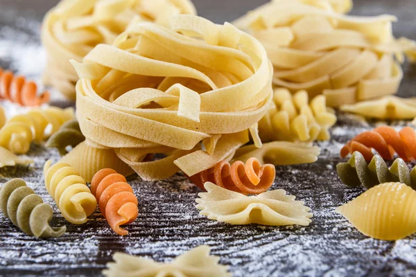 Pasta auf dunklem Holzhintergrund mit Mehl Nahaufnahme Makro — Stockfoto