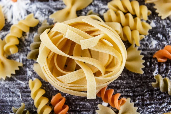 Pasta auf dunklem Holzhintergrund mit Mehl Nahaufnahme Makro — Stockfoto