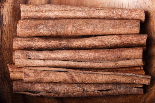 Cinnamon sticks canella on wooden background close-up macro