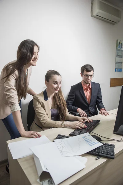 Três estudantes comunicar jovem empresário olhando para documentos — Fotografia de Stock