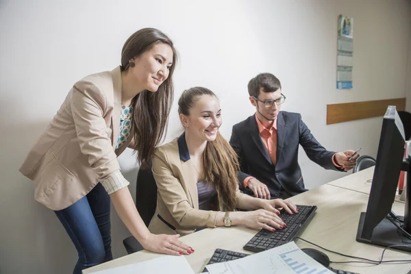 Três estudantes comunicar jovem empresário olhando para documentos — Fotografia de Stock