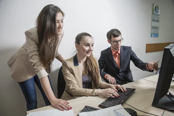 Três estudantes comunicar jovem empresário olhando para documentos — Fotografia de Stock